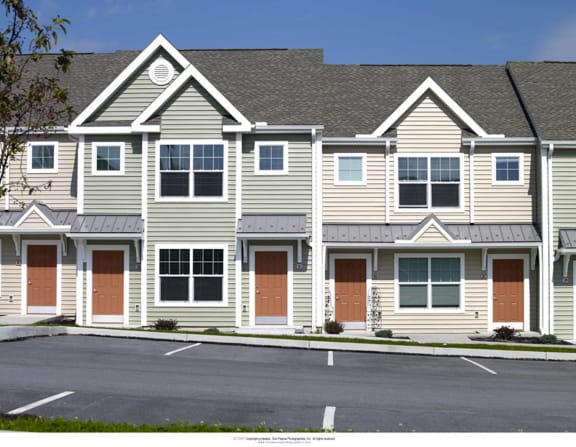a street view of an apartment building with a parking lot