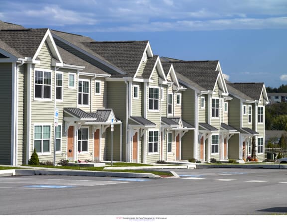 a row of town houses with a street in front of them