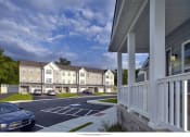 Thumbnail 1 of 3 - a rendering of an apartment complex with cars parked in a parking lot