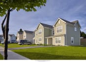 Thumbnail 3 of 6 - a row of houses with cars parked on a street