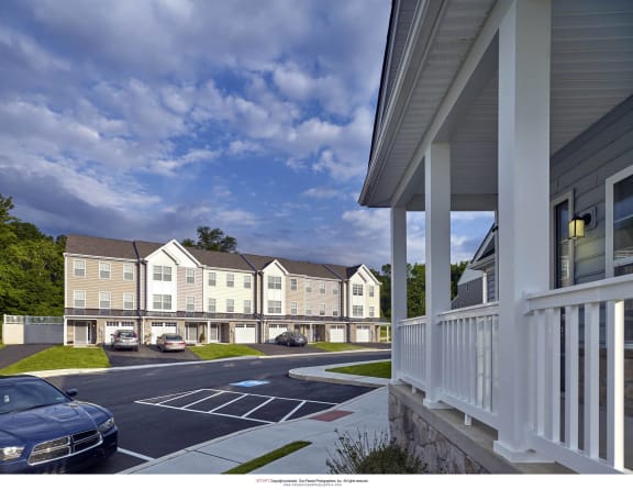 a rendering of an apartment complex with cars parked in a parking lot