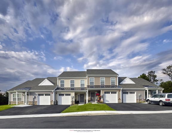 a rendering of a large house with cars parked in front of it