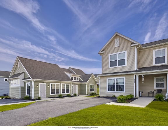 a row of houses with a driveway and grass