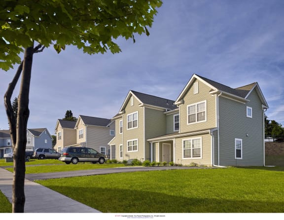 a row of houses with cars parked on a street