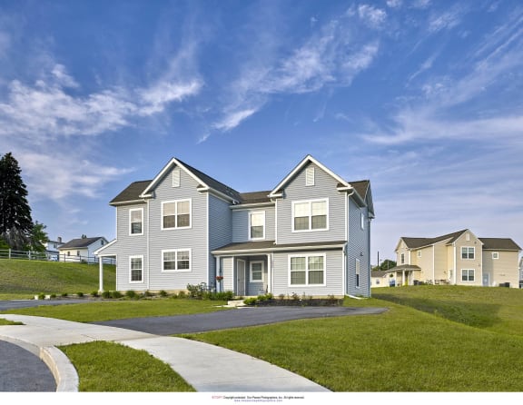 a blue house with a sidewalk in front of it