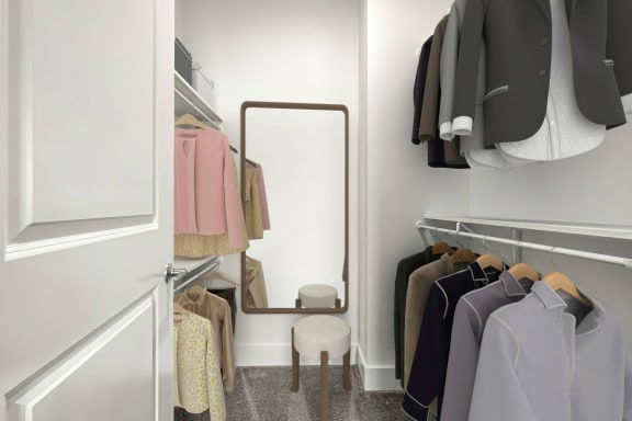 a walk in closet with a mirror and a rack of clothes