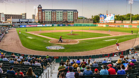 A baseball game is being played in a stadium with a crowd watching.