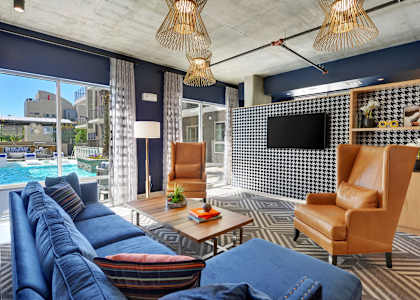 a living room with blue couches and a large window with a pool in the background