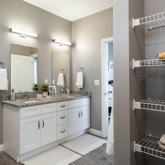 A bathroom with a white vanity and a white toilet.