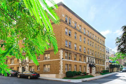 a large brick building with cars parked in front of it