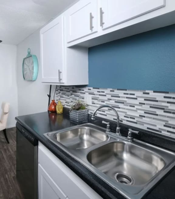 Fifteen 50 modern kitchen with a black countertop and a stainless steel sink.
