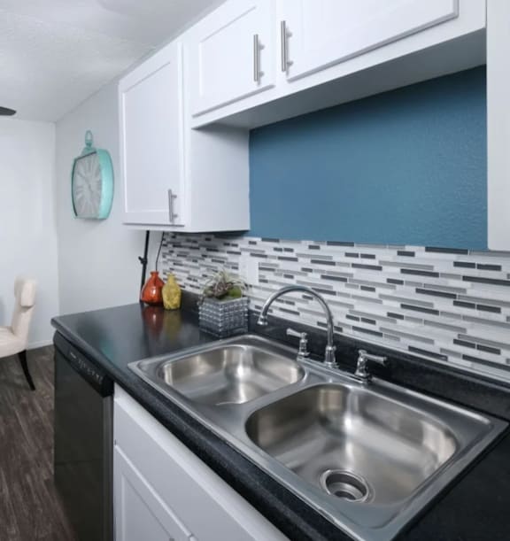 Fifteen 50 modern kitchen with a black countertop and a stainless steel sink.