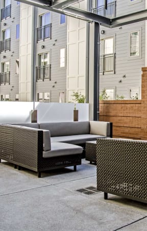 a patio with furniture and a television on a brick wall