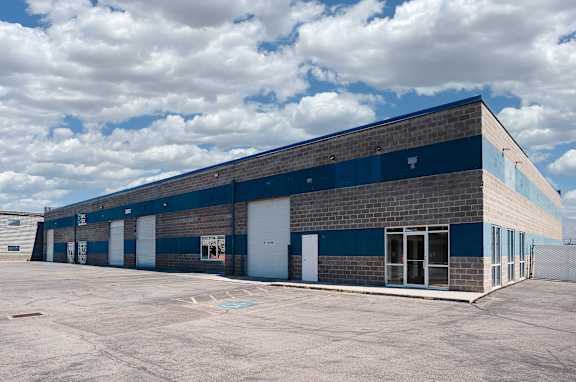 A large industrial building with a parking lot in front.
