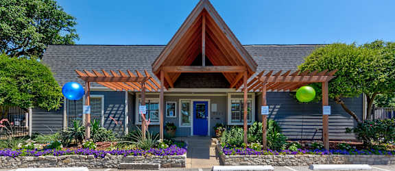 A house with a blue door and a wooden roof with a pergola.