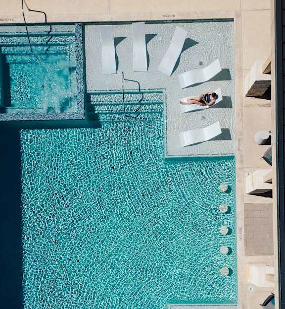 A blue and white mosaic tile with a person swimming in the background.