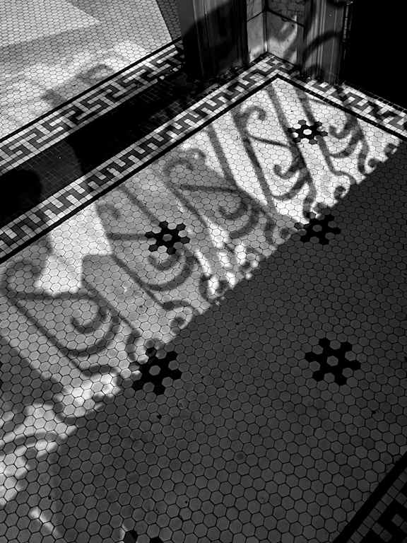 A black and white image of a tiled floor with a decorative border.