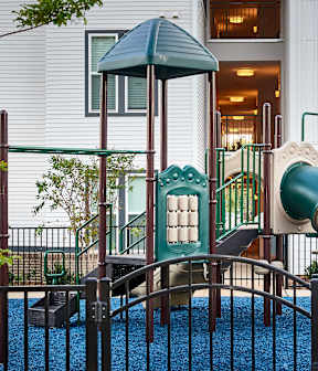 A playground with a green slide and a blue carpet at Beckett Farms Apartments, PRG Real Estate Management, Fort Mill