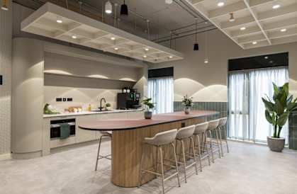 a kitchen with a bar and chairs in front of a window