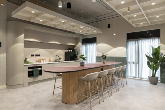 a bar in a room with chairs and a sink