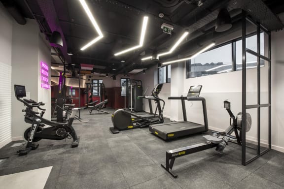a gym with weights and exercise equipment on the floor and a window