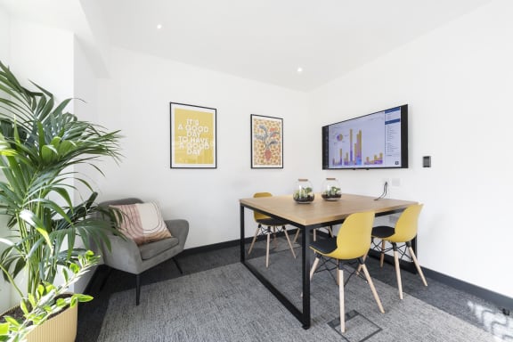 a dining area with a table and chairs and a television