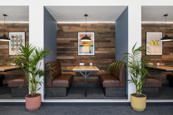 a dining room with brown chairs and a table in front of a wooden wall