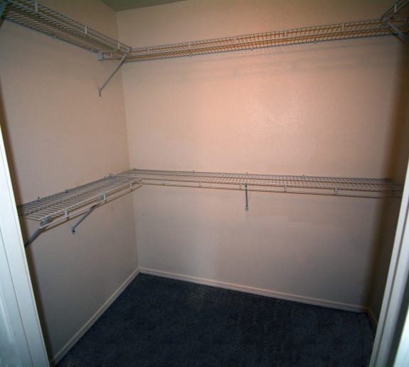 Image of walk in closet with hanger racks and shelves