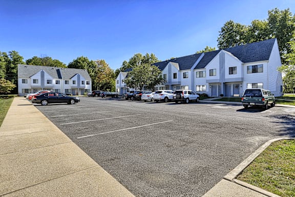 a parking lot with cars parked in front of houses