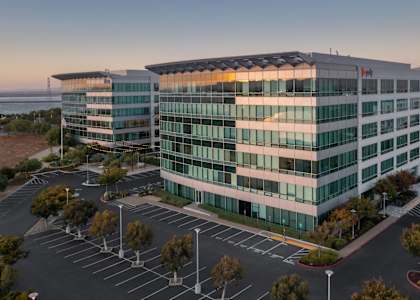 A modern building with a parking lot in front of it.
