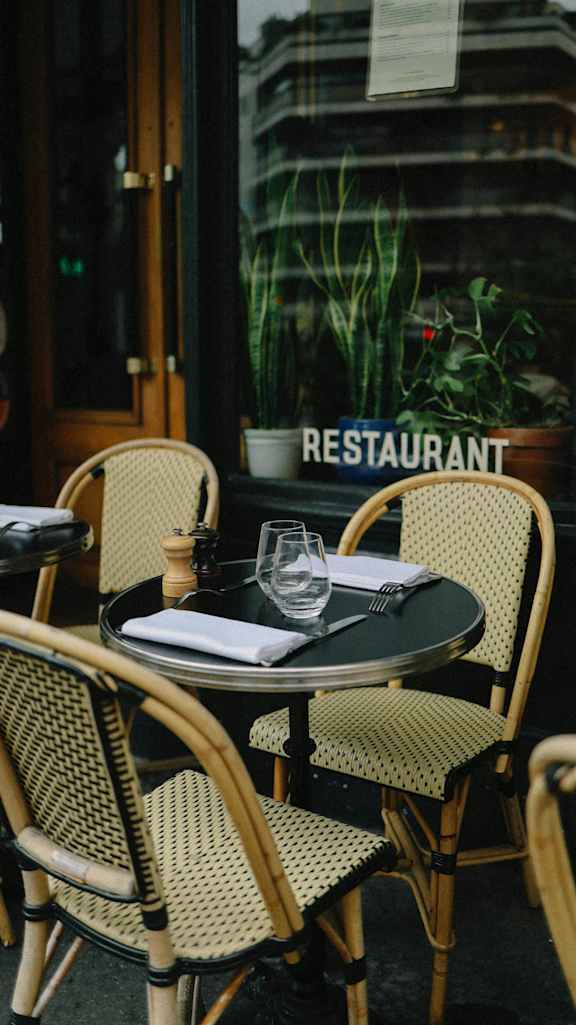 a table outside of a restaurant with a glass on it