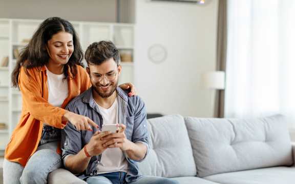 A couple sitting on a couch at Bridgewater Apartments in Duluth, GA, 30096