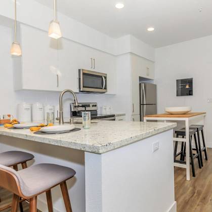 a kitchen with a marble counter top and bar stools