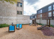 Thumbnail 4 of 7 - an outdoor playground with slides and swings at an apartment building