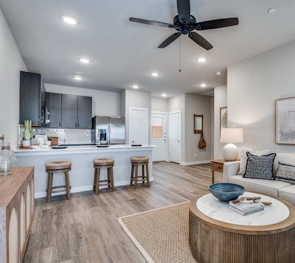 A modern living room with a bar area and a kitchen in the background.