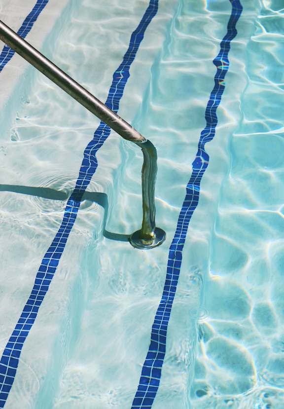 A pool with a metal pole sticking out of the water.