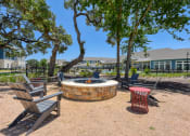Thumbnail 1 of 28 - a fire pit with chairs and trees and a building in the background at Estraya Boerne, Boerne