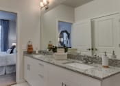 Thumbnail 23 of 28 - a bathroom with white cabinets and granite counter top and a mirror at Estraya Boerne, Texas, 78006