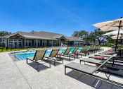 Thumbnail 5 of 28 - a pool with chairs and umbrellas and a building in the background at Estraya Boerne, Boerne, TX, 78006