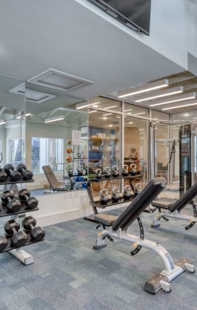 a spacious fitness center with exercise equipment and windows