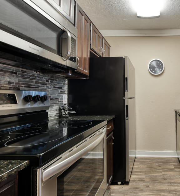 a kitchen with black cabinets and stainless steel appliances
