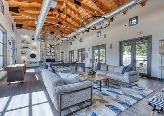 A living room with a grey couch and a blue and white rug.