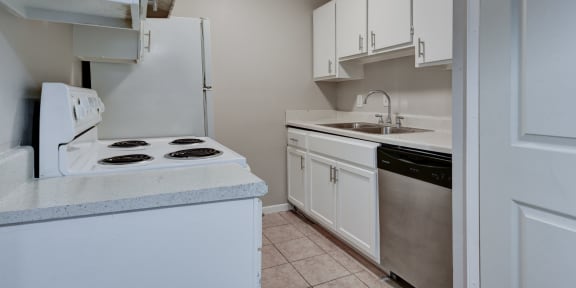 a kitchen with white cabinets and a white stove top oven  at Mayfield Gardens, San Antonio, 78211