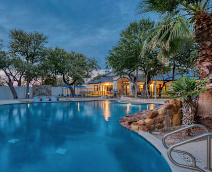 a large swimming pool with a house in the background