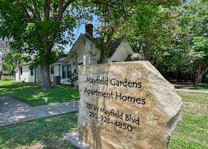 a stone sign in front of a house