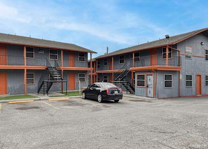 a car parked in front of a motel with a building at The Crossings at Montrose Apartments, San Antonio, Texas