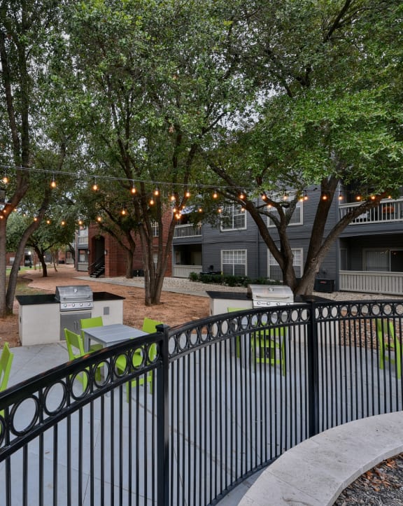 a courtyard with tables and benches and lights