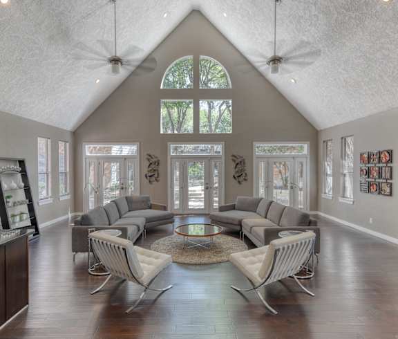 a living room with a vaulted ceiling and large windows