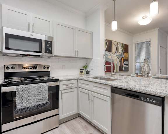 a kitchen with white cabinets and a granite counter top