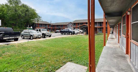 a view of a building with cars parked in a parking lot at The Crossings at Montrose Apartments, San Antonio, Texas